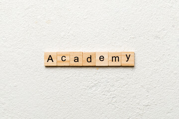 ACADEMY word written on wood block. ACADEMY text on cement table for your desing, concept