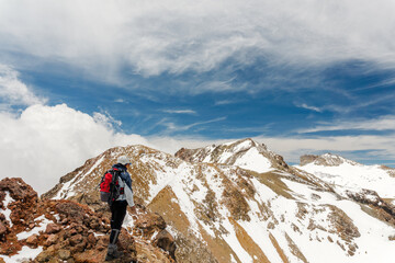 Naklejka premium Alpinist ascending a snow slope high in the mountains
