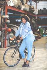 Naklejka premium Big african american woman modeling. Old Machine auto parts in warehouses. Auto mechanic car service, repair and maintenance concept. used car-auto mobile spare parts