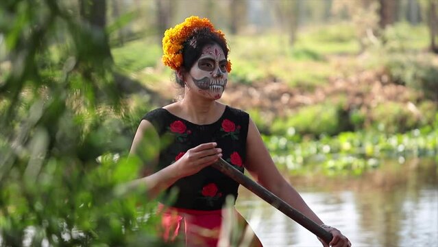mexican woman disguised as a catrina with cempasuchil in canoe for day of the dead celebration in xochimilco