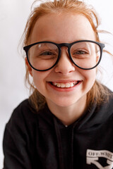 Funny smiling kid girl with glasses on white background