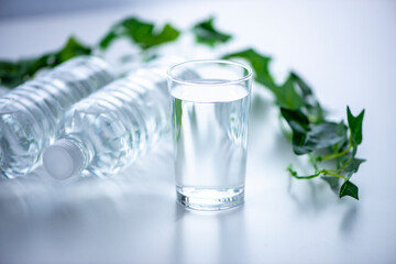 テーブルに置いたコップとペットボトル
