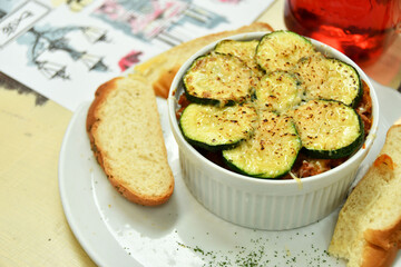 Ratatouille acompañado de pan blanco y una bebida natural de frutos rojos.
