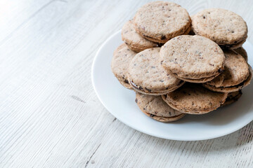 Blurred image of chocolate chip cookies on a light table. The concept of home baking.