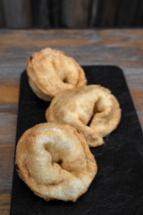 Cheese and ham pies. Closeup view of traditional fried empanadas in a black tablet on the wooden table. 