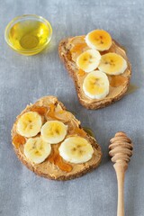 Slices of bread with peanut butter, bananas and honey