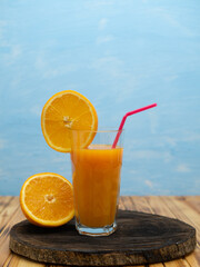 Orange juice in a glass with a slice of orange and an straw