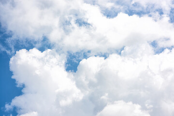 Fluffy white clouds on background of blue sky.