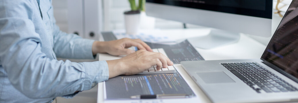 Professional development programmers are sit on a desk with work equipment such as: computer-laptop-tablet. for working in programming or writing code on  website,  HTML, javascript, Software.