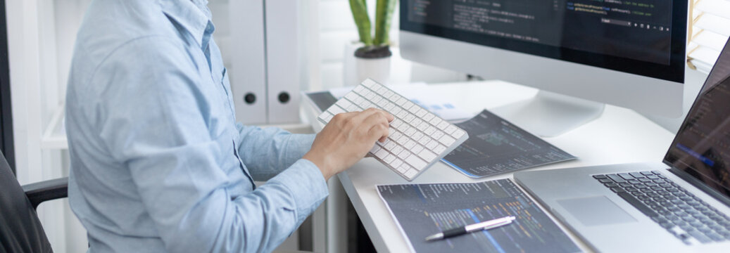 Professional development programmers are sit on a desk with work equipment such as: computer-laptop-tablet. for working in programming or writing code on  website,  HTML, javascript, Software.