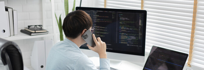 Professional development programmers are talking on the phone with their colleagues for website planning or programming on computers, Write information or code for website,  HTML, javascript, Software