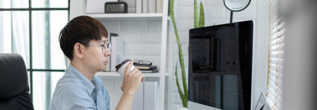 Professional development programmers are sipping coffee in a private office, Working on coding or programming on a computer, Write information or code for the website,  HTML, Javascript, Software.