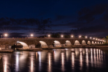 Steinerne Brücke nachts beleuchtet mit Spiegelung in Regensburg