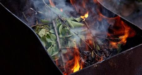 Burning red hot sparks fly from fire. Barbecue gril with glowing and flaming hot charcoal and...