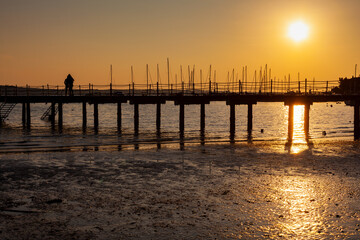 Fototapeta premium High quality photo of a pier at sundown. Wooded bridge seaside with Sunset, Strunjan. Slovenia