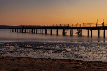 Fototapeta na wymiar High quality photo of a pier at sundown. Wooded bridge seaside with Sunset, Strunjan. Slovenia