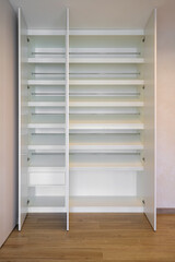 Open white wardrobe with internal shelves