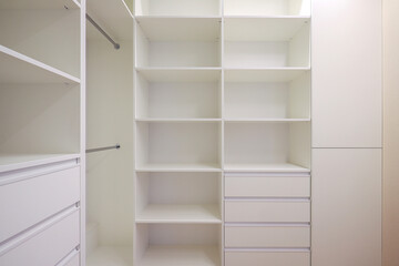 White wardrobe with shelves in the dressing room