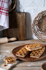 Cookies with raspberry jam on a wooden plate