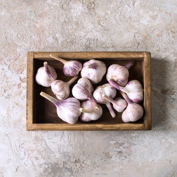 wooden box with fresh garlic on light table