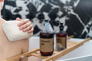 woman taking bath with soft sponge and shower gel, cropped shot