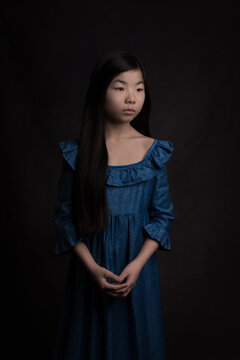 Classic renaissance studio portrait of an asian girl in blue dress