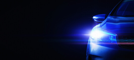 Car headlights with light rays and copy space, selective focus, banner. Light of blue car headlights on a dark background, panorama
