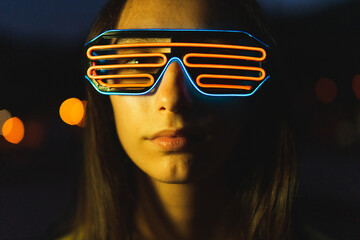 Young woman in futuristic glasses at night