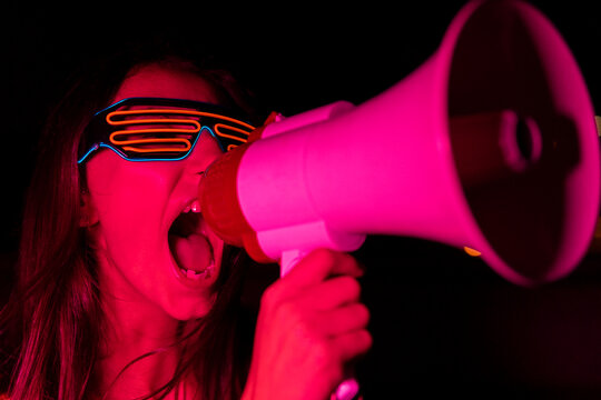 Young woman screaming in loudspeaker