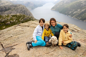 Family, enjoying the hike to Preikestolen, the Pulpit Rock in Lysebotn, Norway on a rainy day,...