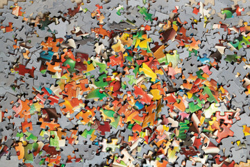 Many colourful puzzle pieces scattered in a pile
