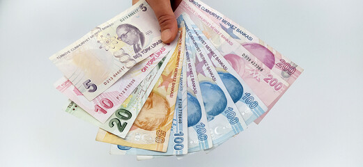 Two-handed Turkish coins (200-100 -50-20-10 Turkish Lira) on a white background