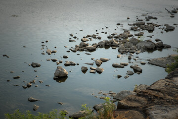 Stones in the placid water of Arno river