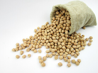   chickpeas in antique sack . Uncooked dried chickpeas in sack isolated on burlap background....