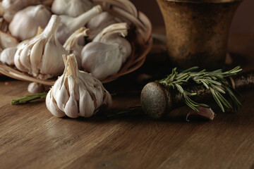 Garlic and rosemary on an old wooden table.