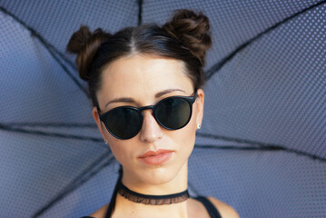 Portrait of goth ballerina holding parasol and wearing sunglasses in abandoned building