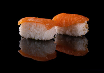Sushi with red fish on black background