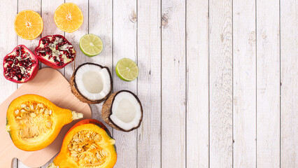 Creative arrangement of healthy fruits on cuting board on wooden background. Flat lay