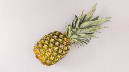 Fresh ripe pineapple on grey backgorund. Flat lay. Summer fruits concept