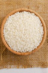 Dry camolino rice in a wooden bowl. The concept of healthy eating. Rustic style. Selective focus. Vertical orientation. Top view.