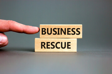 Business rescue symbol. Concept words Business rescue on wooden blocks on a beautiful grey table grey background. Businessman hand. Business rescue and support concept. Copy space.