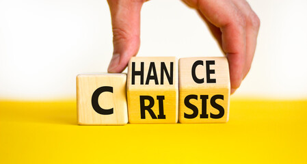 Crisis or chance symbol. Businessman turns wooden cubes and changes the concept word Crisis to Chance. Beautiful yellow table white background, copy space. Business and crisis or chance concept.