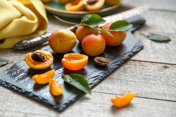 Ripe juicy apricots in a white bowl on a wooden background