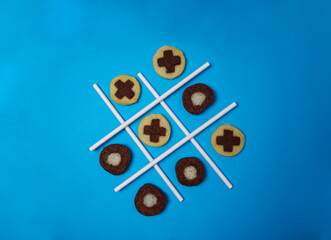 Tic tac toe game with freshly baked cookies on blue background