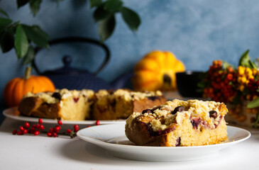 Fruit pie on the table against the background of seasonal vegetables, a basket with an autumn bouquet and a blue background