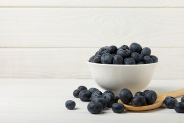 Blueberries in a bowl on white textured background. Ripe and fresh blueberries. Vitamins. Healthy food. Juicy berry.Copy space.Place for text