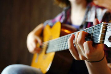 Fototapeta premium The girl teenager plays the guitar.