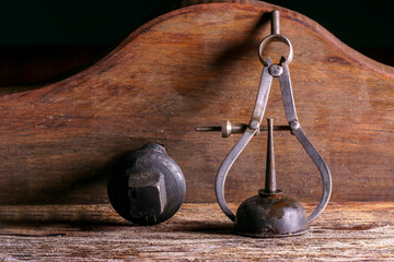antique oil can and compass covered in dirt on a rustic wooden base