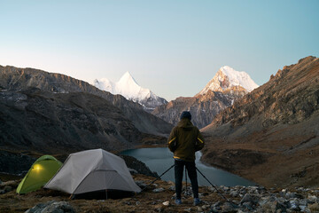 asian photographer taking a photo of mountain and lake in yading national park