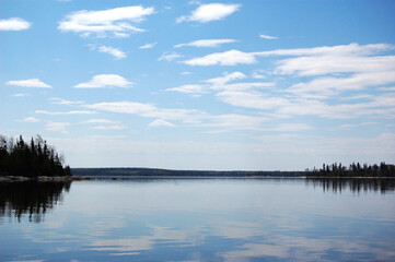 Breathtaking view of the natural reflections cast upon the calm glossy waters of Lac Seul, Ontario, Canada.